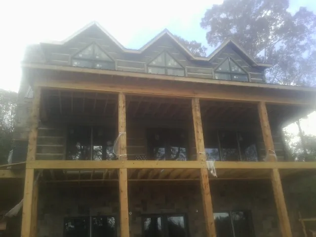 Dormers and porch framing on a large log home under construction — Roof Coating work by our crew in Upper Sandusky