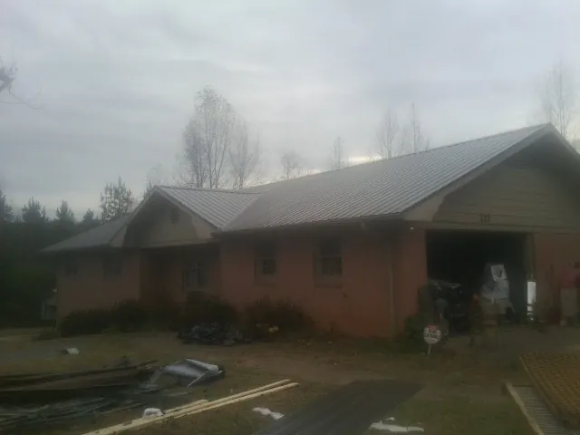 Gray metal roof on a stucco house with an attached garage in Upper Sandusky