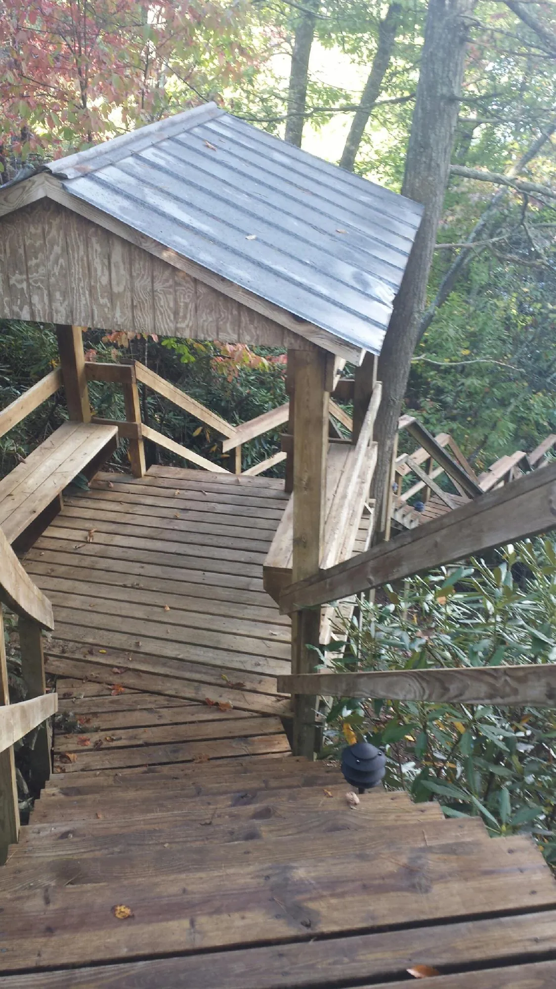 Metal roofed shelter over wooden steps on a wooded walkway — Skylight Repair & Installation work by our crew in Upper Sandusky